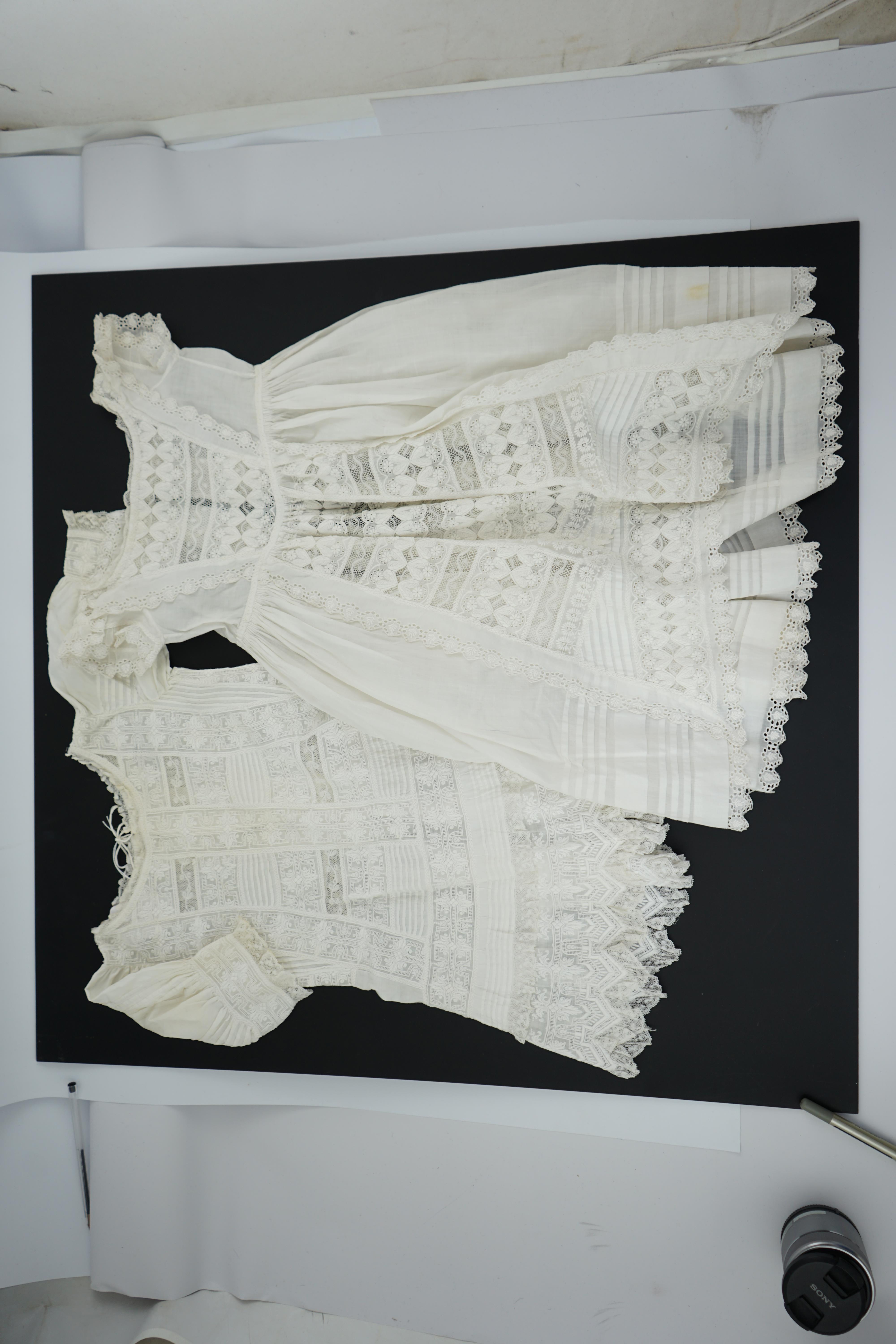 Two unusual 19th century intricately white worked children’s dresses, one hand worked with fine panels of white work, feather stitching and tucking, edged and inserted with hand made Valenciennes lace, the other worked i